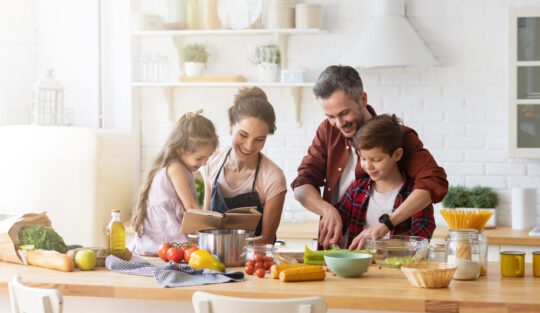 O familie fericită care gătește alături de copiii săi