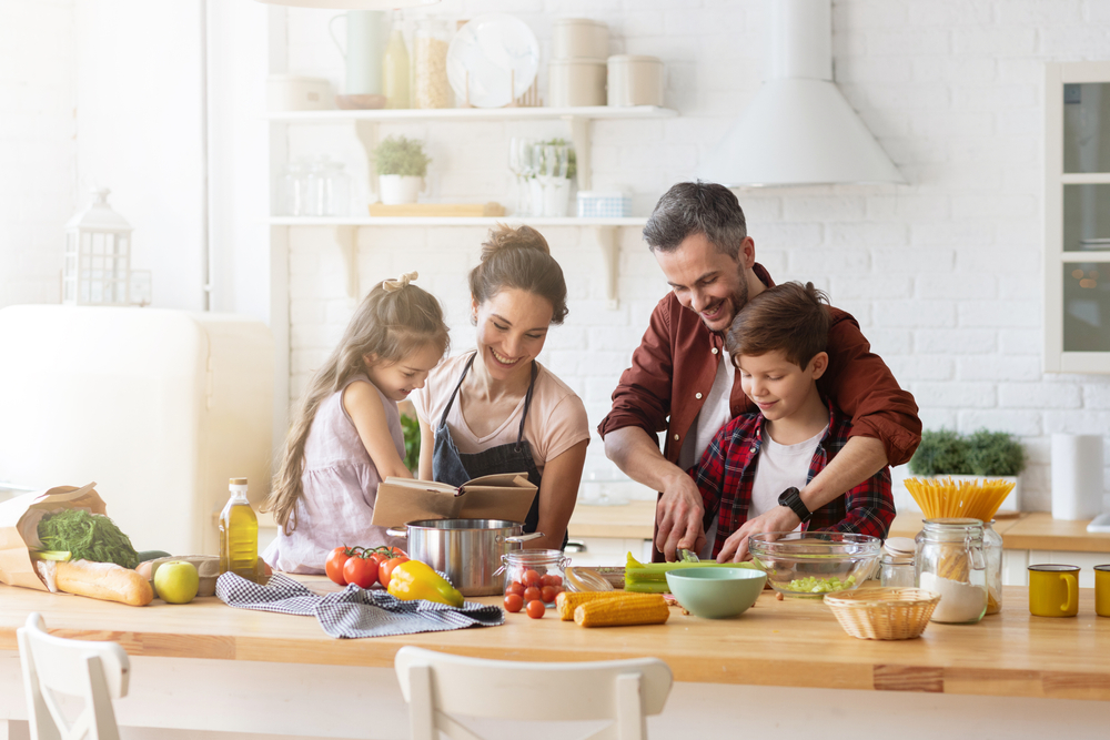 O familie fericită care gătește alături de copiii săi