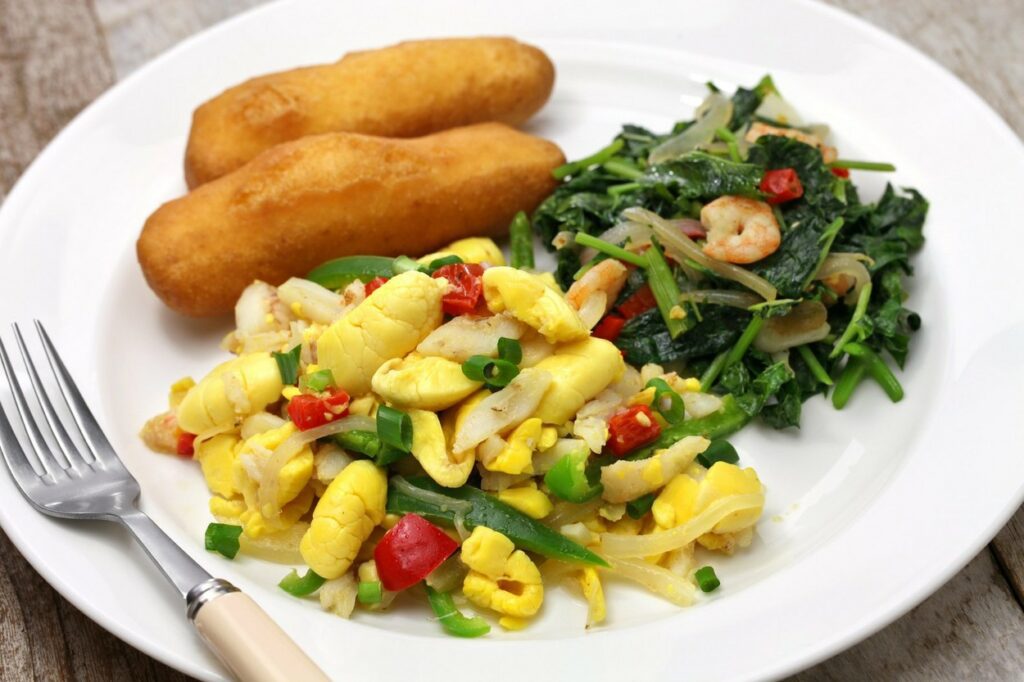 Micul dejun jamaican conține multe fructe și este servit în cazul de față pe o farfurie albă
