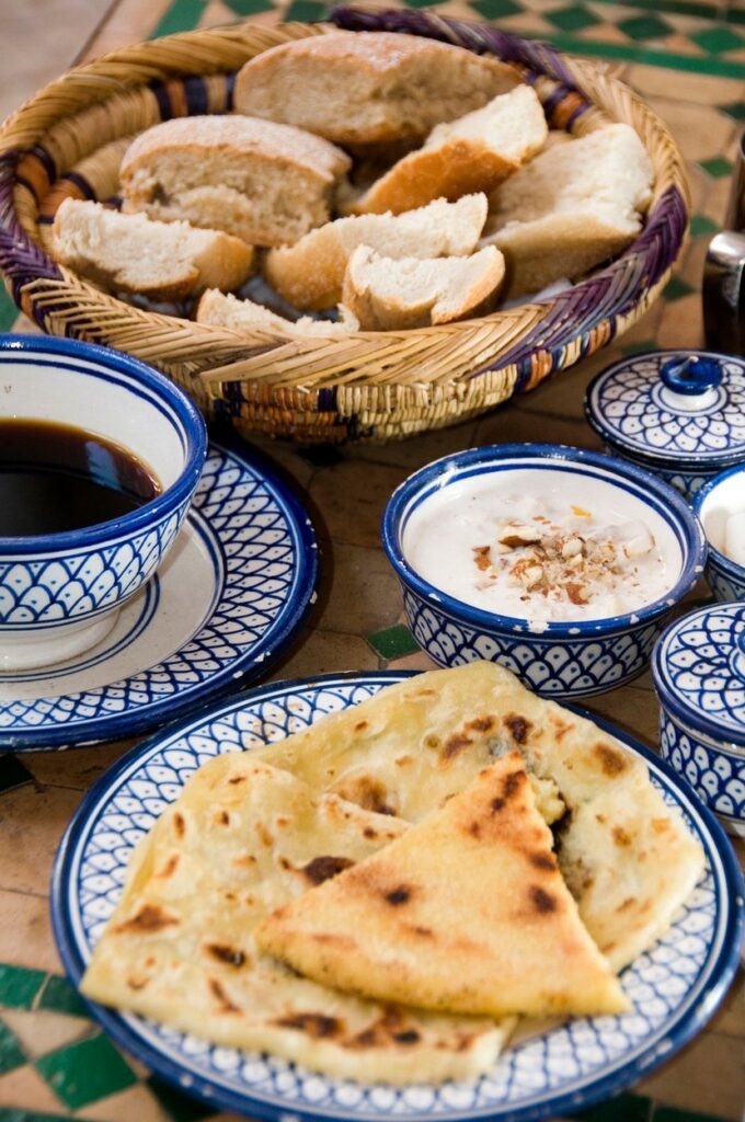Mic dejun tradițional marocan servit pe farfurii albe cu albastru