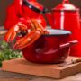 O oală roșie în care se află un homar care așteaptă să fie gătit