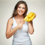 O femeie veselă cu un mănunchi de banane în mână