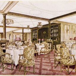 Sala de mese a vasului Titanic, cu scaune cu tapițerie scumpă, aurie și mese rotunde, cu acoperite cu fețe de masă de un alb imaculat.