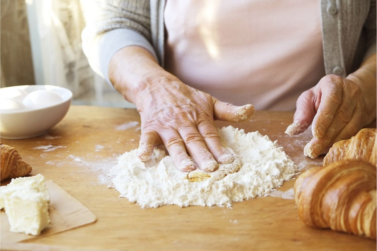 femeie în vârstă gătind un aluat