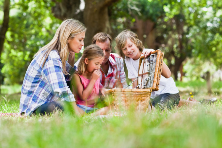 O familie uitându-se la ce preparate pentru picnic au în coș