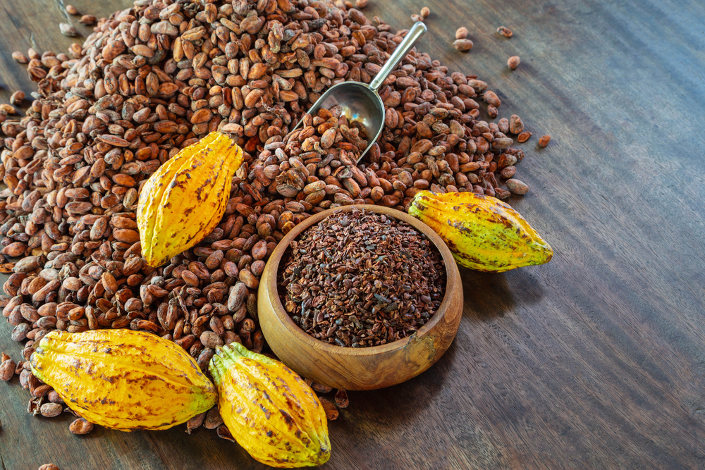 O masă gri pe care se află un coșuleț cu boabe de cacao fiind unul din cele 6 alimente noi pe care să le introduci chiar azi în dieta ta