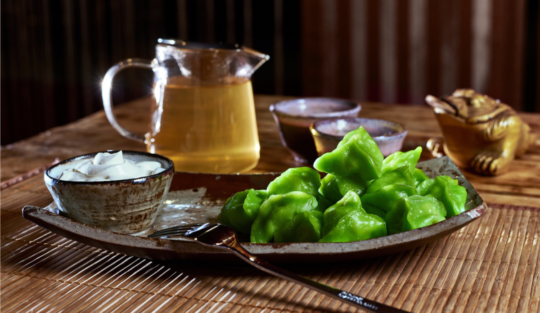 O cană de ceai verde, așezată pe un platou.