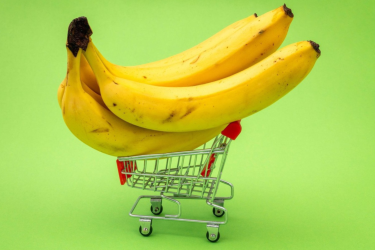 Banane într-un coș de cumpărături pentru a ilustra beneficiile acestora și motivul pentru care sunt considerate ieftine