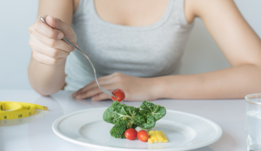 O femeie care ține dieta cu deficit caloric și consumă câteva alimente