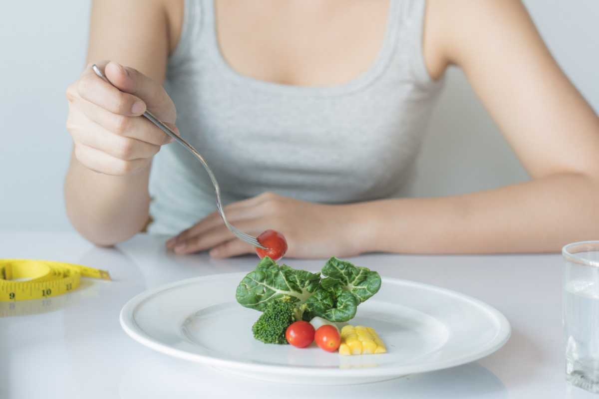 O femeie care ține dieta cu deficit caloric și consumă câteva alimente