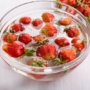 Căpșuni, într-un bol transparent, plin cu apă