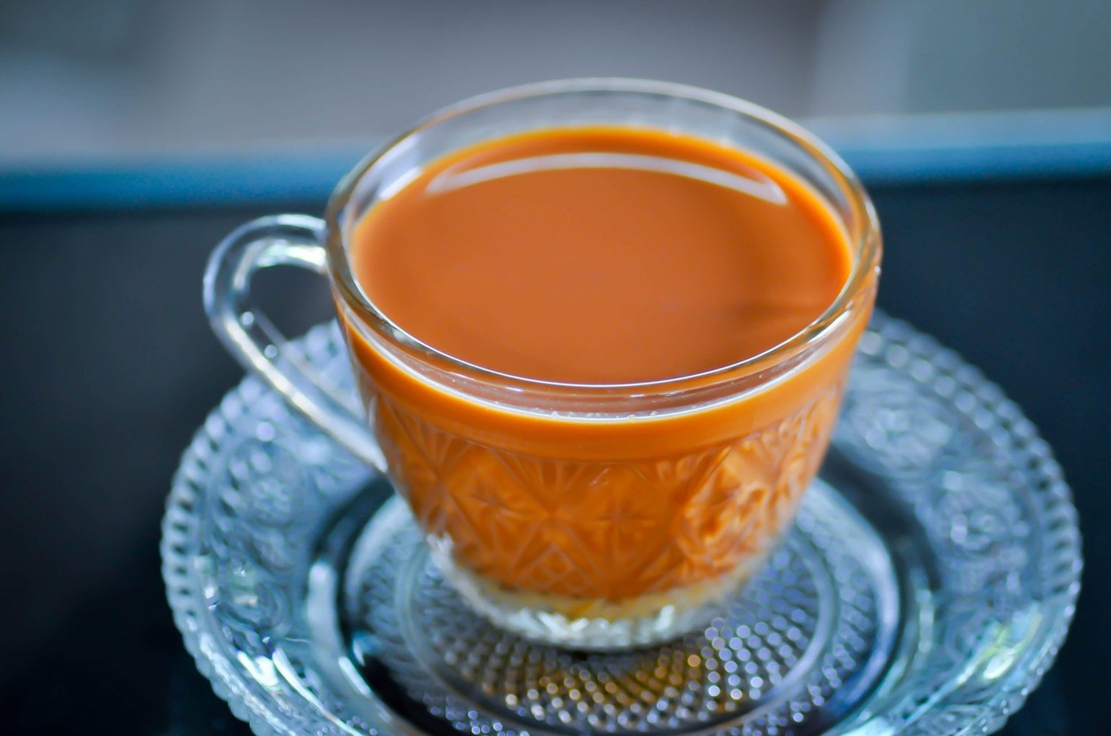 Ceai cu gheață thailandez într-o ceașcă cu farfurie
