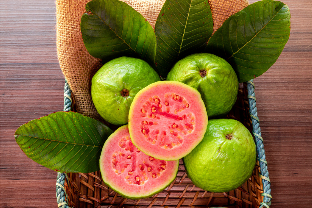 Fructe guava într-un coș, fie întregi, fie tăiate pe jumătate