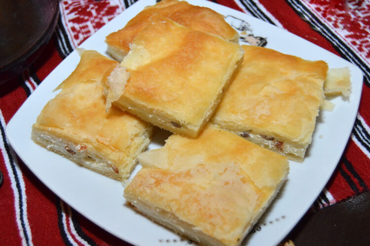 Bucăți de plăcintă cu urdă, unul dintre cele mai populare deserturi din România, așezate pe o farfurie albă.