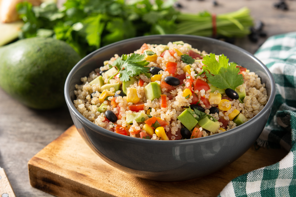 Salata de quinoa pusă într-un bol mare și negru