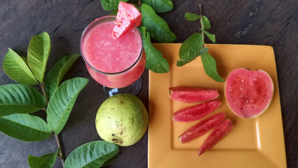 Fructe de guava tăiate felii, pe un blat din lemn