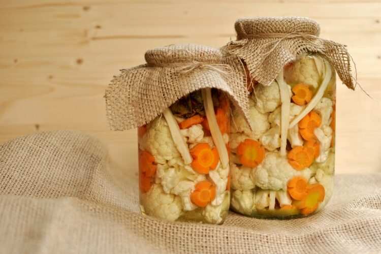 Două borcane cu conopidă murată cu morcovi și hrean