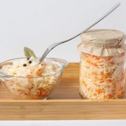 Salată de varză cu morcovi în borcan și în bol cu furculiță
