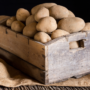 O cutie de lemn plină de cartofi care îți arată cum poți păstra cartofii 6 luni