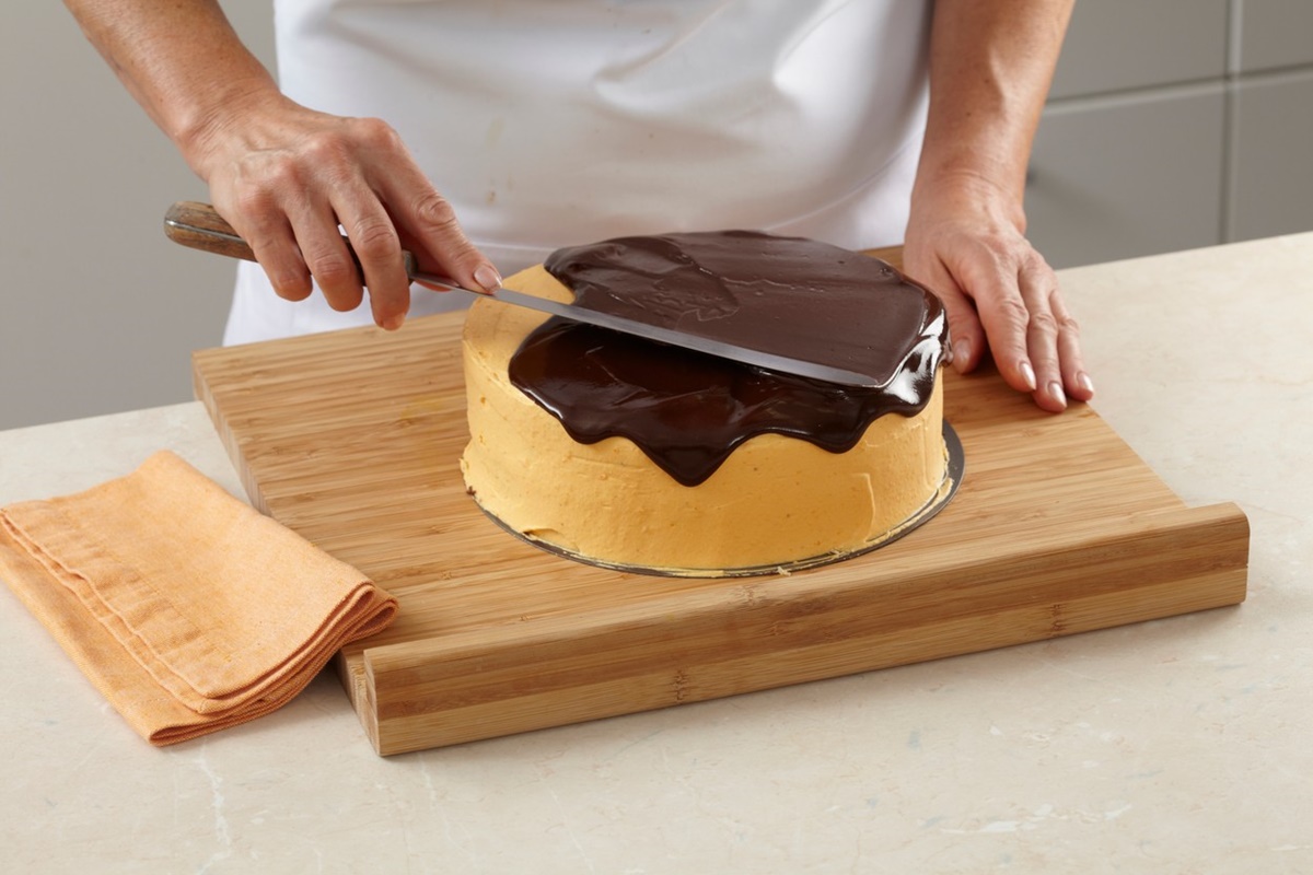 Pasul de întindere a glazurii de ciocolată peste tort cu cremă de dovleac copt