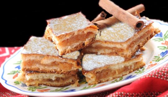 porții de plăcintă cu mere și dulceață de gutui, gustoasă și foarte aromată pe o farfurie, decorate cu batoane de scorțișoară