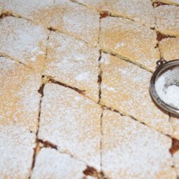 Plăcintă porționată în tavă și decorată cu zahăr pudră