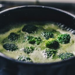 Oală neagră cu bucăți de broccoli în apă pentru fiert