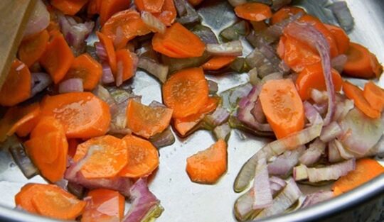 Ceapă și morcovi călite într-o cratiță cu ulei