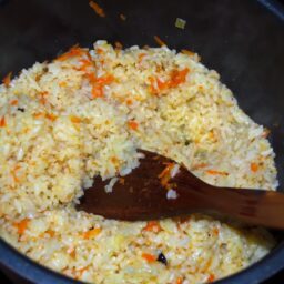 Amestec de orez fiert cu morcov răzuit și ceapă, cu o paletă de lemn