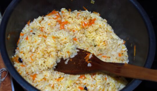 Amestec de orez fiert cu morcov răzuit și ceapă, cu o paletă de lemn