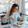 O femeie care mănâncă o salată la un restaurant și se bucură de masa sa