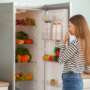 O femeie care se uită într-un frigider fără curent electric