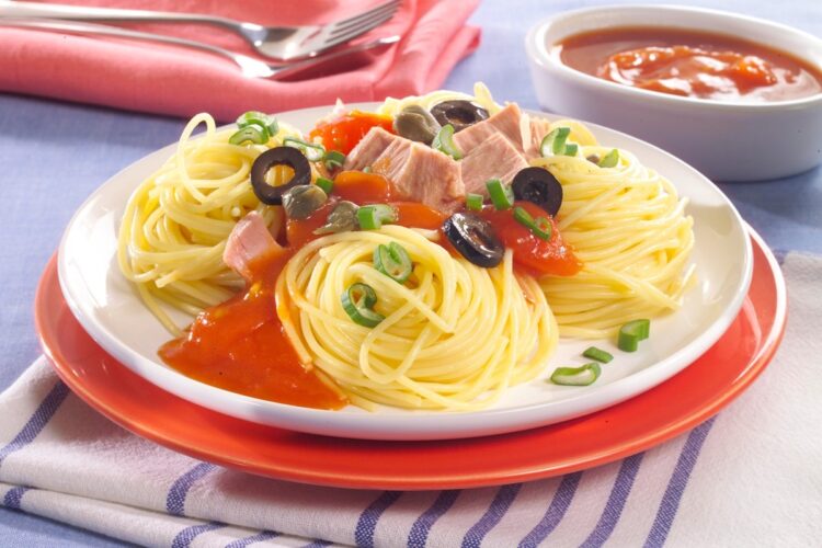 Spaghete cu ton și sos de roșii, decorate cu măsline, capere și ceapă verde