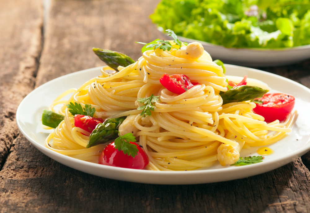 Spaghete preparate cu roșii și servite într-o farfurie albă