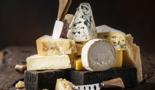 Mai multe tipuri de brânză aranjate unul peste altul