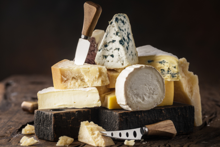 Mai multe tipuri de brânză aranjate unul peste altul
