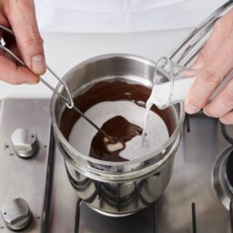 Adăugare de lapte în sosul ciocolatos