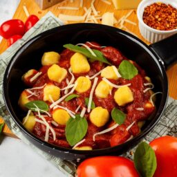 Tigaie cu sos de roșii preparat și amestecat cu gnocchi de cartofi