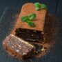 Tort de biscuiți cu ciocolată și alune de pădure decorat cu pudră de cacao și frunze de mentă