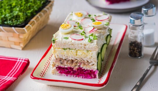 Tort sandviș din bucătăria suedeză, secționat pe un platou dreptunghiular