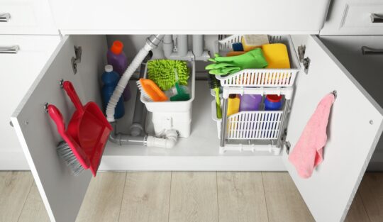 Dulapul de sub chiuveta din bucătărie amenajat cu diverse obiecte de uz casnic