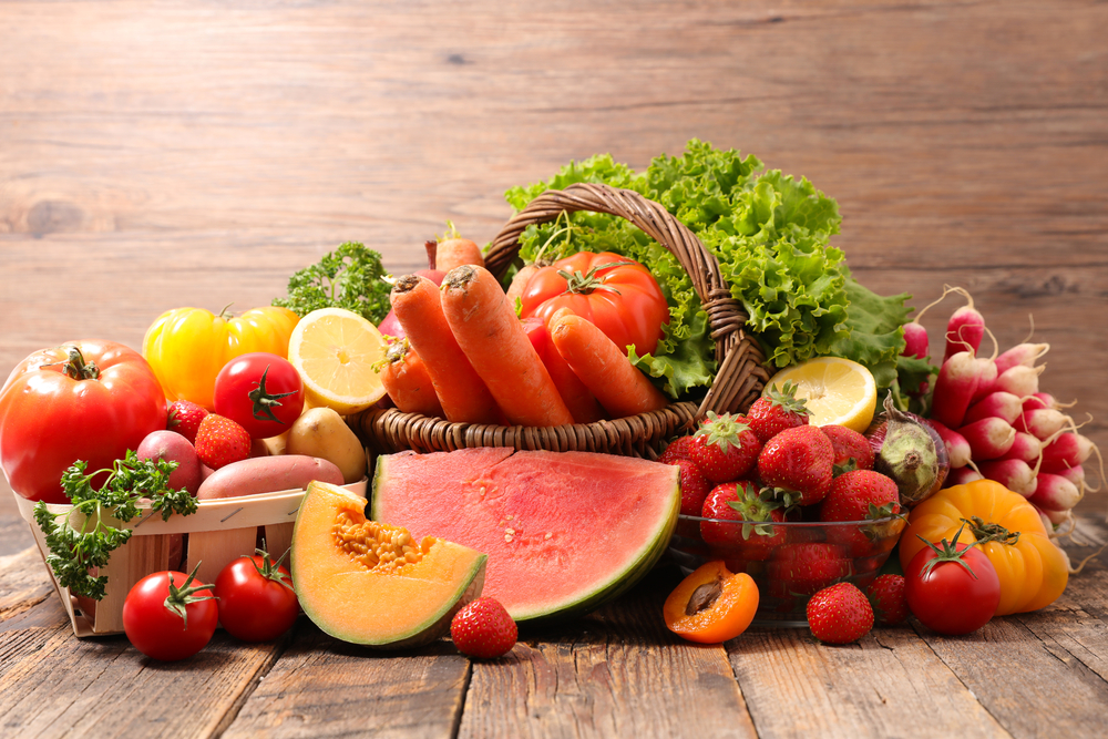 Frcute din sezonul de vară, pepene, mere, căpșune, pe o masă de lemn