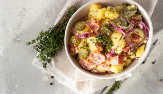 Salată de cartofi pusă într-un bol alb, preparată cu un ingredient secret