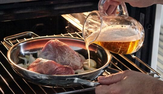 Adăugare bere peste carnea de porc introdusă în cuptor