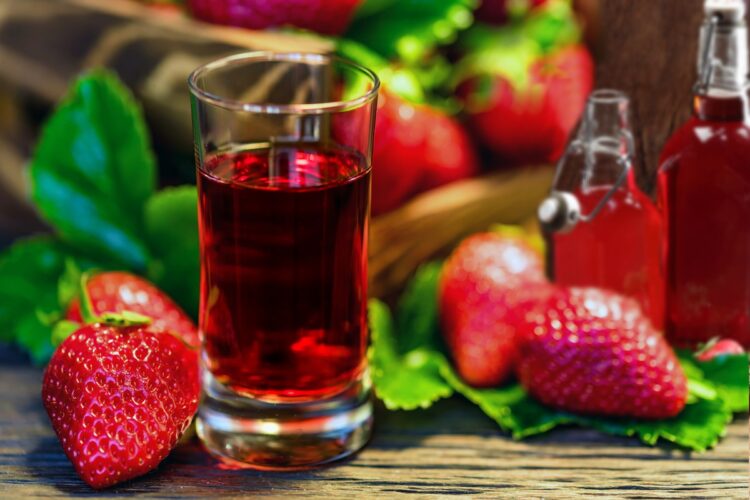 Lichior de căpșuni sau Căpșunată în pahar și în două sticle, alături de căpșuni proaspete