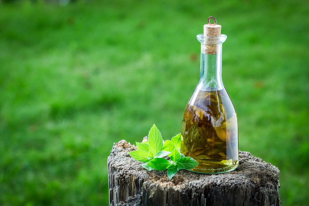 Sticlă cu lichior de mentă și frunze de mentă pe o butură