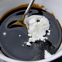 Amidon amestecat cu lingura într-un bol cu sos de soia și sos de pește