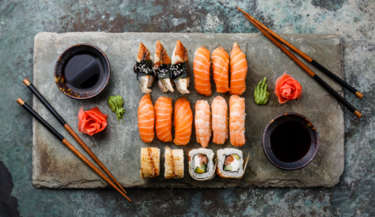 modul corect de a mânca sushi ilustrat cu ajutorul unui platou mare cu sushi
