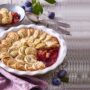 Tartă cu prune și mere și aluat rulat cu scorțișoară în formă albă și o porție într-un bol