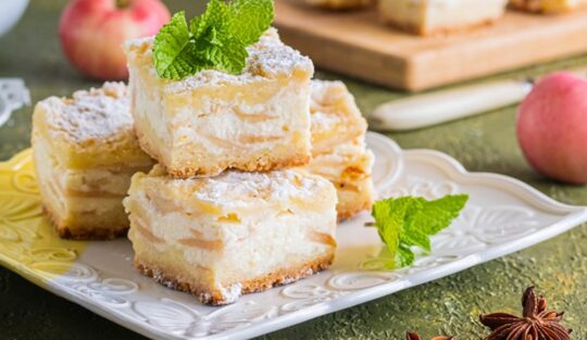 Porții de prăjitură cu mere și brânză pe o farfurie albă, dantelată